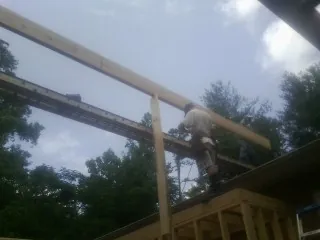 Carpenter setting a ridge beam over a new addition frame — Ice Dam Removal by Roofing Brothers in Charlestown