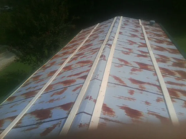Rusted metal roof panels with new wood purlins before replacement — Storm Damage Roof Repair in Charlestown by Roofing Brothers